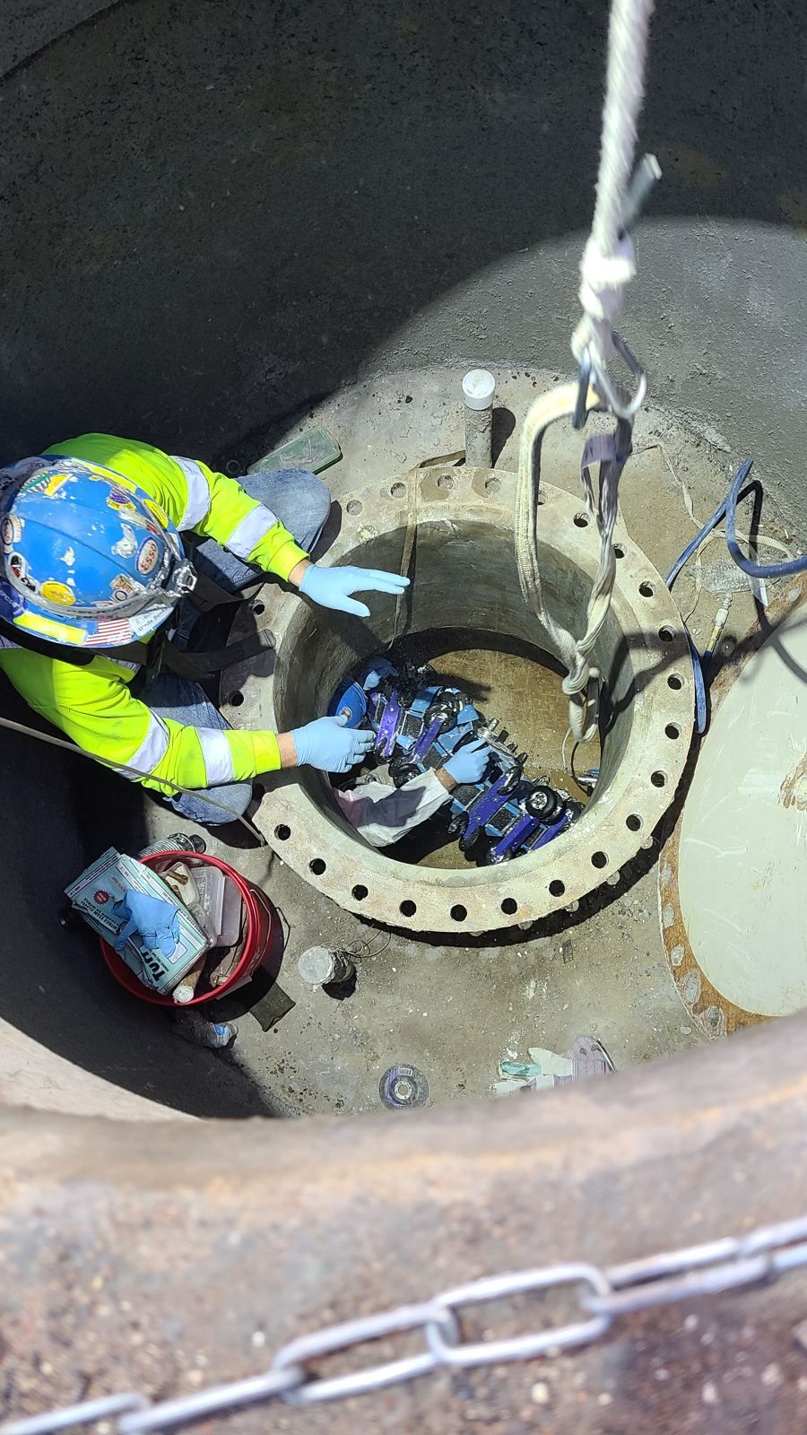 Technician fitting an inspection tool at a flanged pipe access point