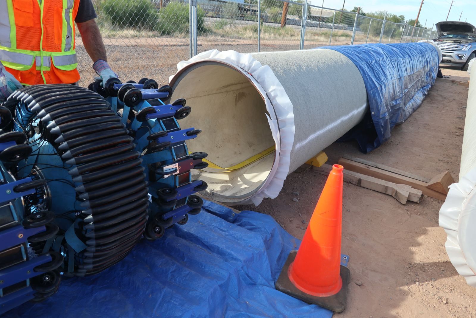 Remote field testing tool beside a mortar-lined concrete pressure pipe section